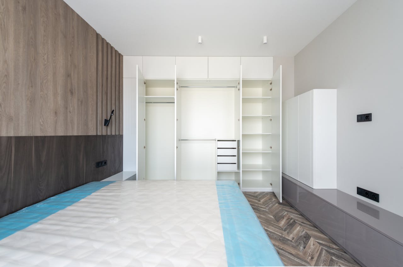 Spacious minimalist bedroom with wooden accents and white cabinetry for a sleek modern look.